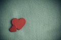 Red wooden decorative hearts on gray cloth background. Royalty Free Stock Photo