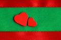 Red wooden decorative hearts on green cloth background Royalty Free Stock Photo