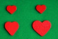 Red wooden decorative hearts on green cloth background Royalty Free Stock Photo