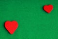 Red wooden decorative hearts on green cloth background Royalty Free Stock Photo