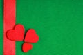 Red wooden decorative hearts on green cloth background Royalty Free Stock Photo