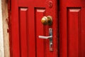 Red wooden door with round ornate handle and traditional handle Royalty Free Stock Photo