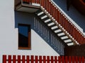 Red wooden exterior stair and fence in strong sun light with shadows