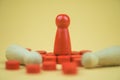 A red wooden figure standing with person figure lie on floor. Business strategy