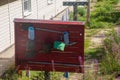 A red wooden fire shield with a tool hanging on it for firefighters. installed on the street next to the house Royalty Free Stock Photo