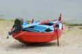 Red wooden fishing boat moored on the shore Royalty Free Stock Photo