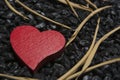 Red wooden heart on a black pebble background. Royalty Free Stock Photo