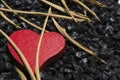 Red wooden heart on a black pebble background. Royalty Free Stock Photo