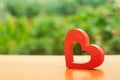 A red wooden heart on nature background. The secret of relationships and the rules of a strong family. Strong love affair. Secrets