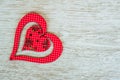 Red wooden heart placed on a white wood board