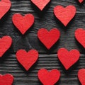 Red wooden hearts on black wooden background