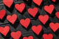 Red wooden hearts on black wooden background