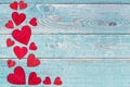 Red wooden hearts on the left border on a blue scaffold wooden background Royalty Free Stock Photo