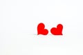 Red wooden hearts side by side look at each other on a white background