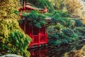 Red wooden house in japanese style garden, park with pond and autumn trees. Traditional japan architecture. Exterior design, Royalty Free Stock Photo