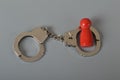 Red wooden people of figure with handcuff locked. Handcuffed convict, law offender and justice concept
