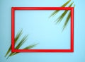 Red wooden picture frame decorated with green wheat heads on blue background Royalty Free Stock Photo