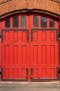 A red wooden portal for several cars. Old Fire station. arch and window with metal decorations.