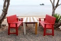 Red wooden table and chairs on the beach. Royalty Free Stock Photo