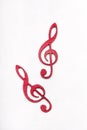 Red wooden treble clef on white background