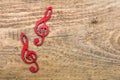 Red wooden treble clef on wooden background,