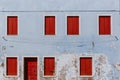 Red wooden windows and door on old light blue wall, on the island of Burano, in Venice, Italy Royalty Free Stock Photo