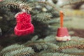 Red wool handmade small hat on Christmas tree outdoor. Diy decoration, yarn crafts creative ideas Royalty Free Stock Photo