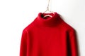 Red wool sweater hanging on clothes hanger on white background.close up Royalty Free Stock Photo