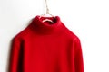Red wool sweater hanging on clothes hanger on white background.close up Royalty Free Stock Photo