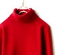 Red wool sweater hanging on clothes hanger on white background.close up Royalty Free Stock Photo