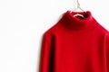 Red wool sweater hanging on clothes hanger on white background.close up Royalty Free Stock Photo