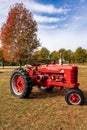 Red "Mccormick Farmall" tractor parked in a grassy field, vertical shot