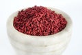 Red yeast fermented rice or kojic riceRed yeast fermented rice on mortar grinding bowl Royalty Free Stock Photo