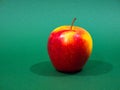 Red yellow apple and slice isolated on green background Royalty Free Stock Photo