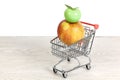 Red and Yellow Apple and Ceramic Green Apple in a Miniature Shopping Cart