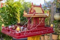 Red and yellow Buddhist sanctuary in tropical garden. Small buddhist temple in red and gold colors. Royalty Free Stock Photo