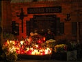 Red and yellow candles on a grave of the Cursed Soldiers at night