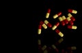 Red, yellow capsule pills on dark background. Antibiotic resi Royalty Free Stock Photo