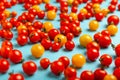 Red and yellow cherry tomatoes on blue background. Fresh bright organic vegetables Royalty Free Stock Photo