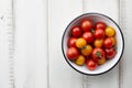 Red and yellow cherry tomatoes on white wooden table Royalty Free Stock Photo