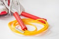 Red and yellow color jump rope with sport shoe Royalty Free Stock Photo