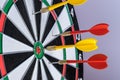 Red and yellow dart arrows hitting in the target center of dartboard. Success hitting target aim goal achievement concept Royalty Free Stock Photo