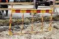 red and yellow fence near the ditch, where workers remove an accident of water pipes