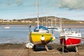 Red and Yellow fishing boats at low tide with boats in background