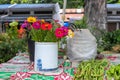 Red and yellow flowers on rustic bucket in village garden. Simple flower bouquet on summer village gazebo