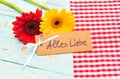 Beautiful gerbera daisy flowers and card with text, Alles Liebe, means love