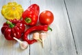 Red, yellow and green bush pumpkins, peppers, garlic on white wood background. Garden,agriculture and farming concept.