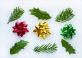 Red, yellow, green gift bows on a white background. Leaves of Holly and fir branches Royalty Free Stock Photo