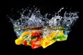 Red yellow and green pepper slices fall into water, on black background Royalty Free Stock Photo