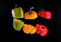 Red, yellow and green peppers, levitation on a black background Royalty Free Stock Photo